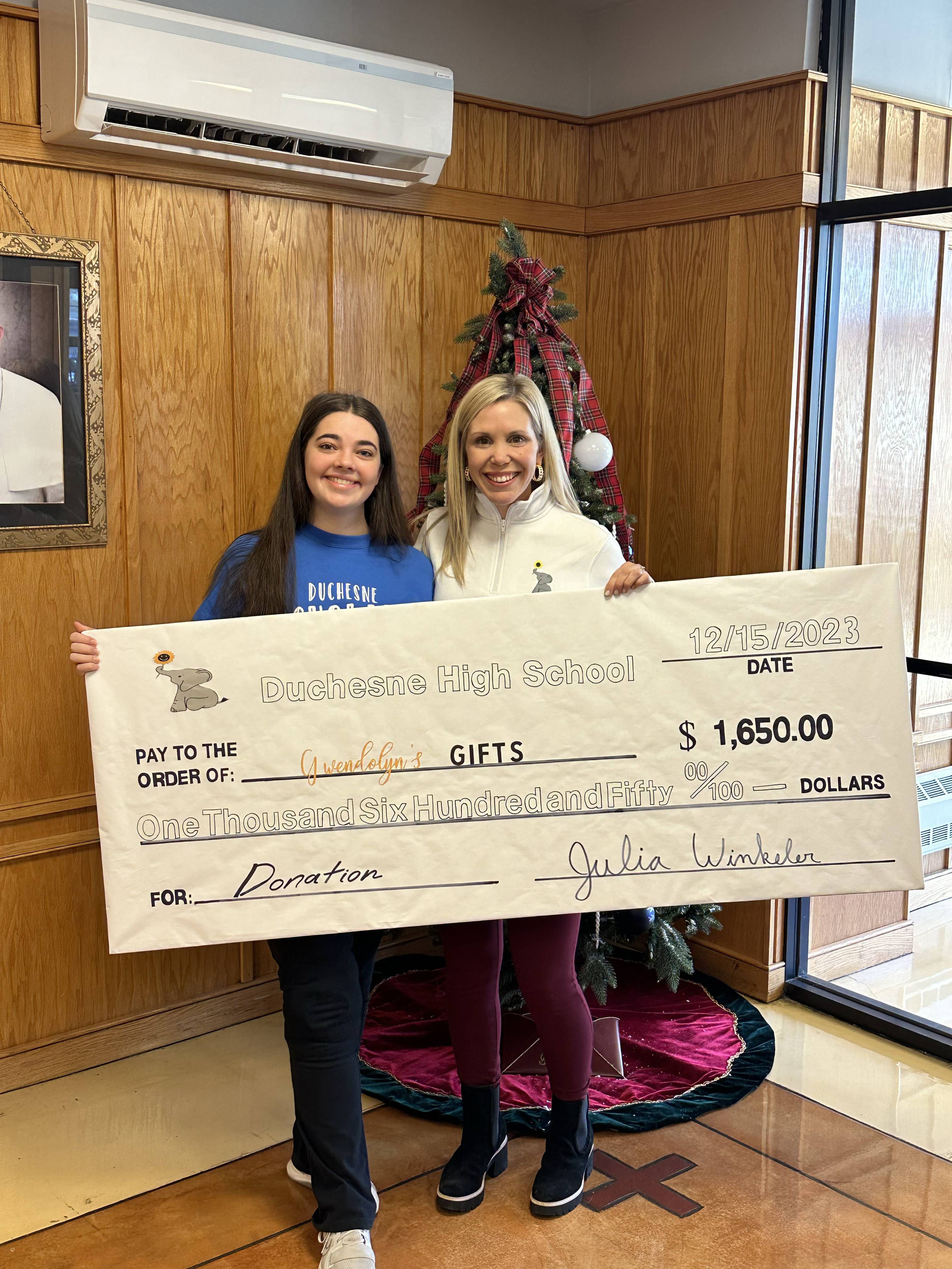 Julia Winkeler ’24 presents Erin Kramer ’04 with a check for Gwendolyn's gifts.